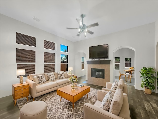 living room featuring a tiled fireplace, a wealth of natural light, hardwood / wood-style floors, and ceiling fan