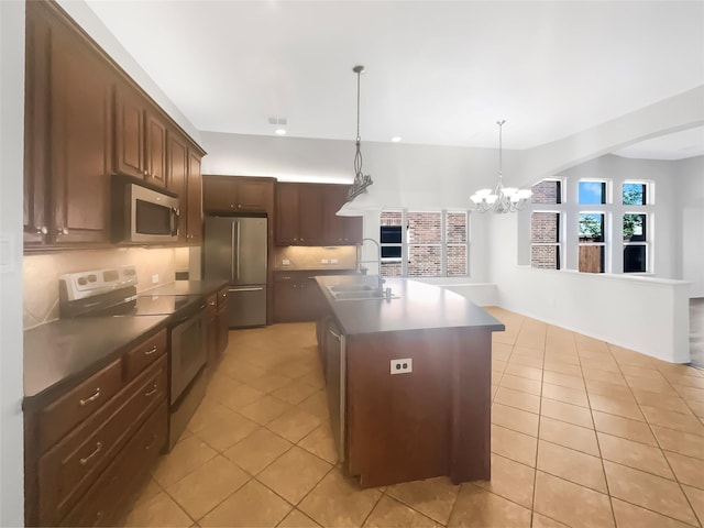 kitchen featuring pendant lighting, sink, a kitchen island with sink, dark brown cabinetry, and stainless steel appliances