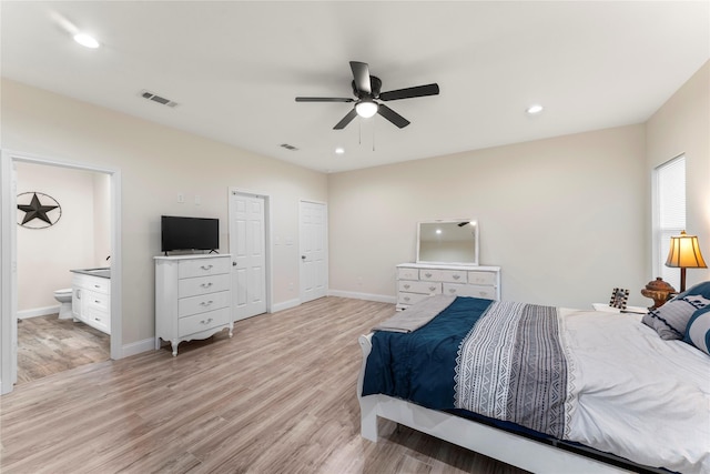 bedroom with ceiling fan, ensuite bath, and light hardwood / wood-style floors