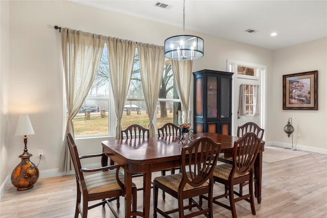 dining area with a notable chandelier and light hardwood / wood-style flooring