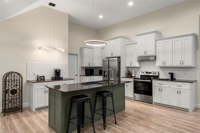 kitchen featuring pendant lighting, a breakfast bar area, stainless steel appliances, an island with sink, and white cabinets