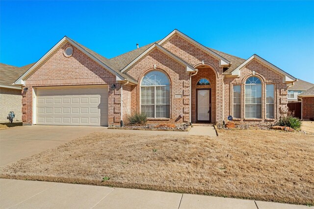 ranch-style house with a garage and a front yard