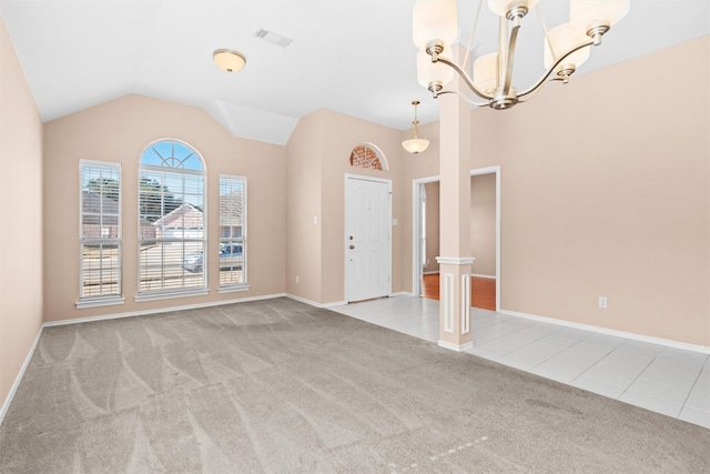 interior space with light colored carpet, an inviting chandelier, light tile patterned flooring, vaulted ceiling, and baseboards