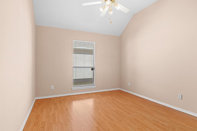 empty room with light wood-type flooring, ceiling fan, baseboards, and vaulted ceiling