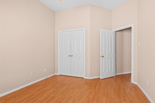 unfurnished bedroom with a closet, light wood-style flooring, and baseboards