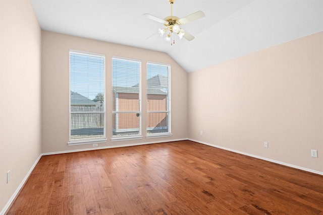 unfurnished room with vaulted ceiling, wood finished floors, a ceiling fan, and baseboards