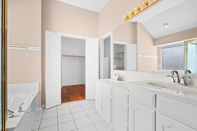 full bathroom featuring lofted ceiling, double vanity, tile patterned flooring, and a sink