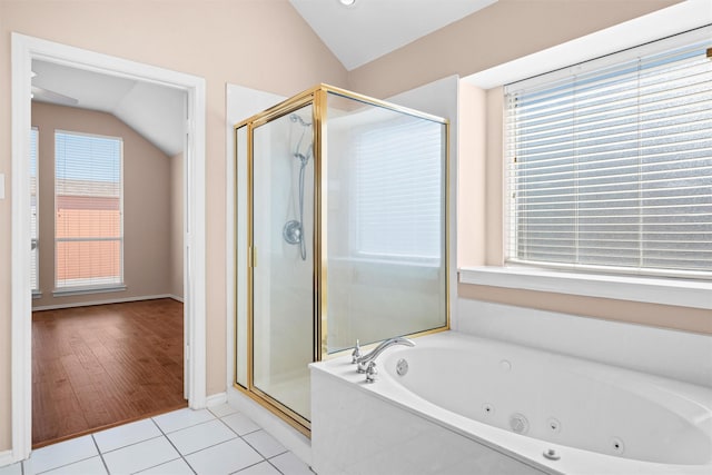 bathroom featuring lofted ceiling, a shower stall, a jetted tub, and tile patterned floors