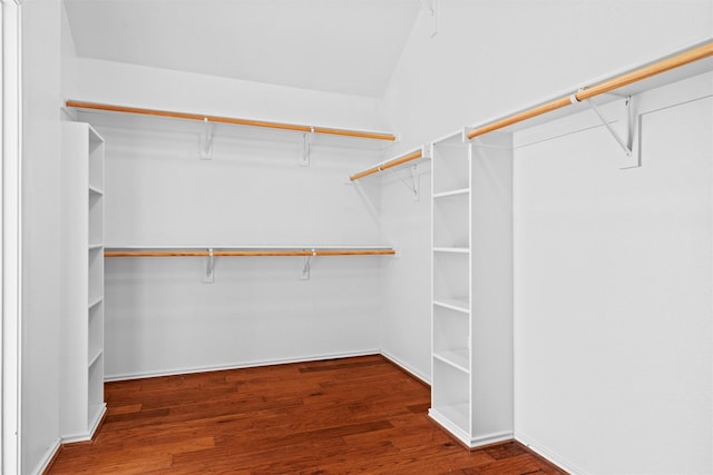 spacious closet featuring lofted ceiling and dark wood-style floors