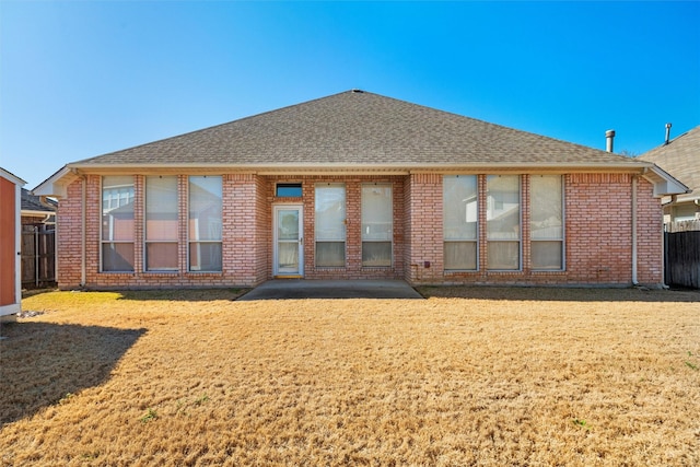 back of house with a shingled roof and brick siding