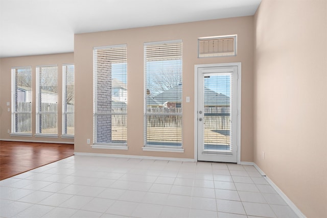 doorway to outside featuring baseboards and light tile patterned floors