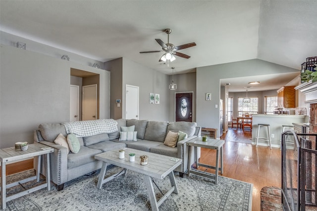 living room featuring ceiling fan, lofted ceiling, and light hardwood / wood-style floors