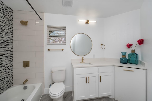 full bathroom featuring vanity, tiled shower / bath combo, and toilet