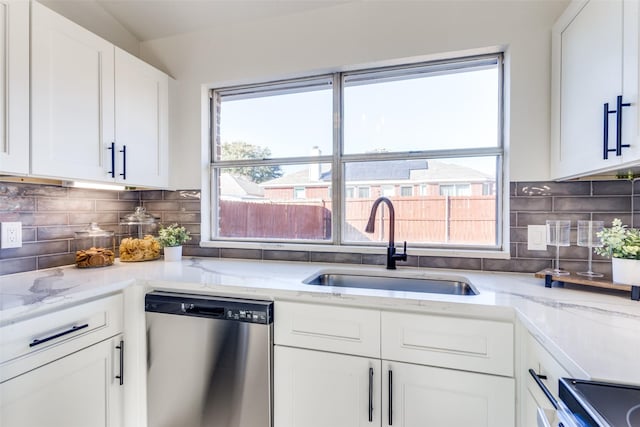 kitchen featuring sink, stainless steel appliances, light stone counters, white cabinets, and decorative backsplash