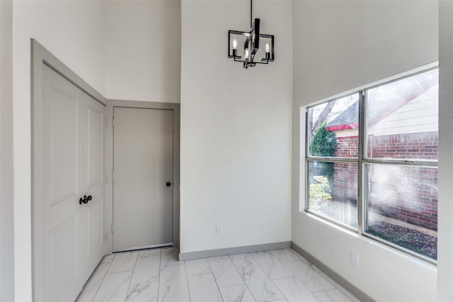 interior space featuring an inviting chandelier and a high ceiling