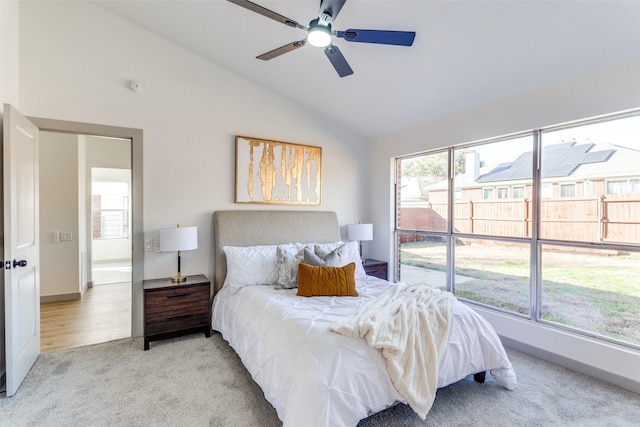 carpeted bedroom featuring ceiling fan, lofted ceiling, and multiple windows