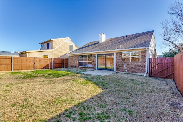 back of house with a lawn and a patio