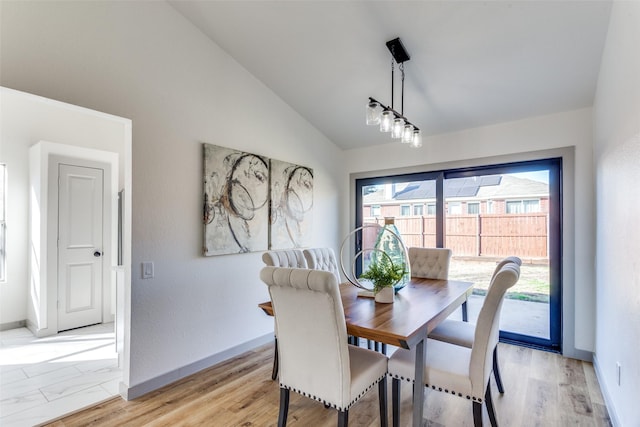 dining space featuring lofted ceiling and light hardwood / wood-style flooring