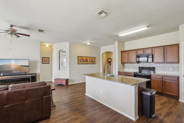 kitchen with dark hardwood / wood-style floors, tasteful backsplash, sink, a kitchen island with sink, and black appliances