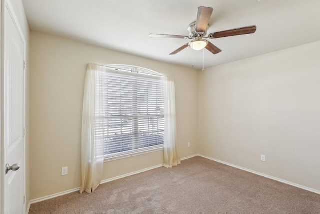 carpeted spare room with ceiling fan