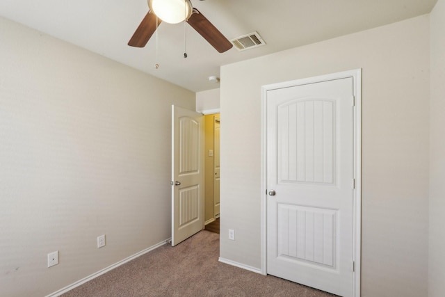 unfurnished bedroom featuring light colored carpet and ceiling fan