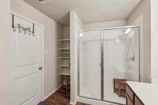 bathroom featuring walk in shower, wood-type flooring, and vanity