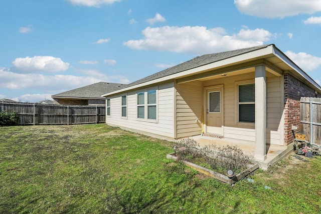 back of house with a lawn