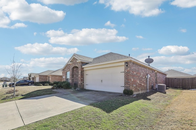 ranch-style home featuring cooling unit, a garage, and a front yard