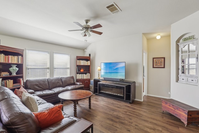 living room featuring ceiling fan and dark hardwood / wood-style floors