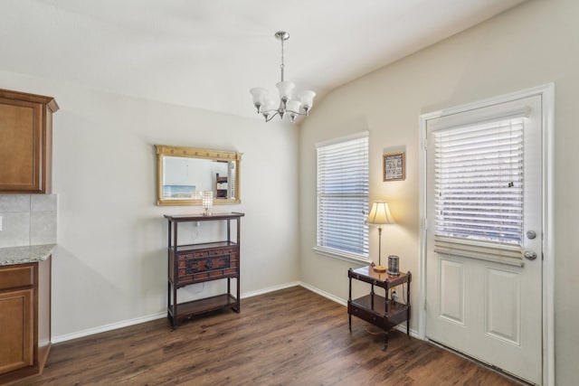 living area with vaulted ceiling, dark hardwood / wood-style floors, and a chandelier