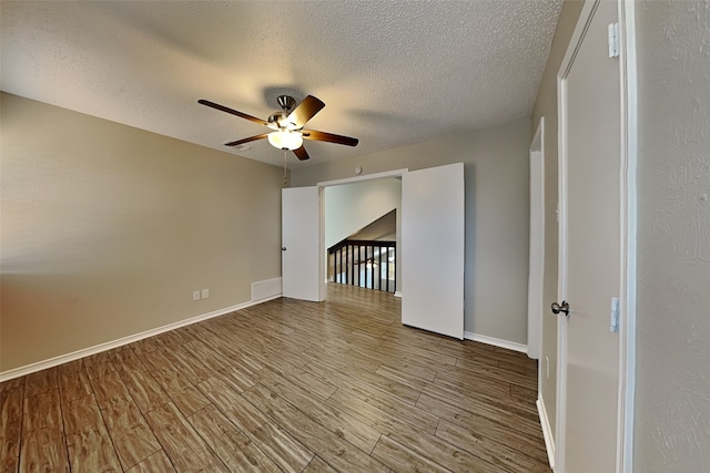 empty room featuring ceiling fan, a textured ceiling, and light hardwood / wood-style floors