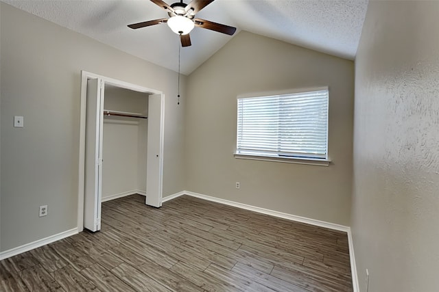 unfurnished bedroom featuring lofted ceiling, ceiling fan, wood-type flooring, and a textured ceiling