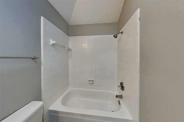 bathroom with tiled shower / bath combo, a textured ceiling, and toilet