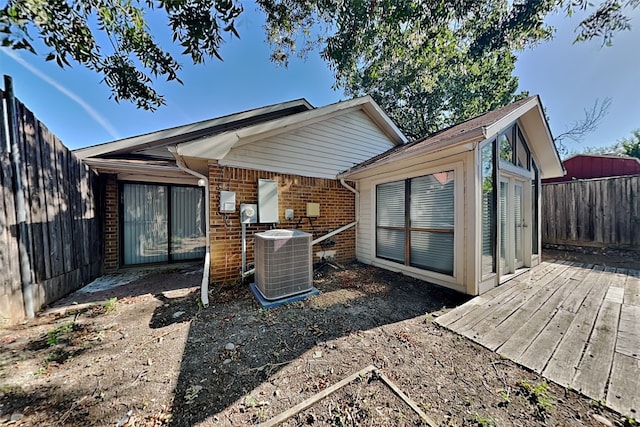 back of house with cooling unit and a wooden deck