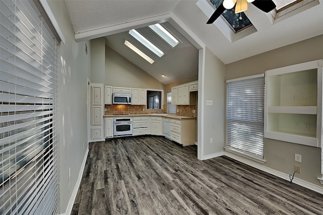 kitchen featuring white cabinetry, appliances with stainless steel finishes, sink, and a skylight