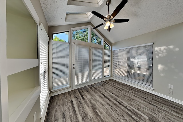 unfurnished sunroom with ceiling fan and vaulted ceiling with skylight