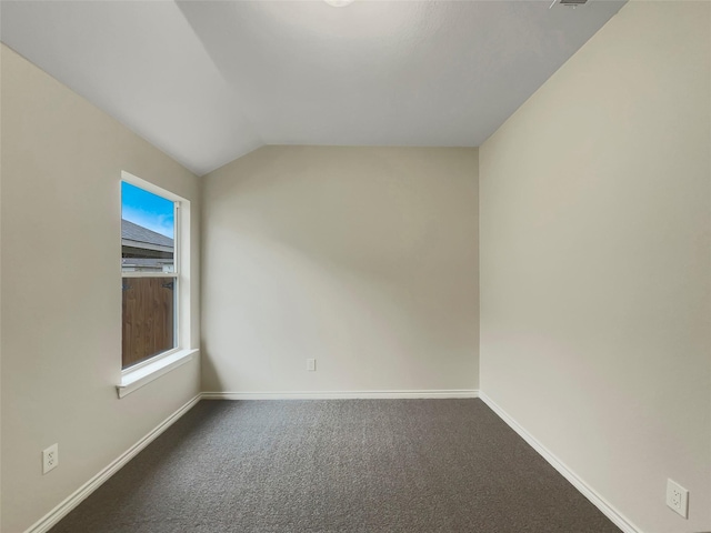 carpeted empty room with vaulted ceiling