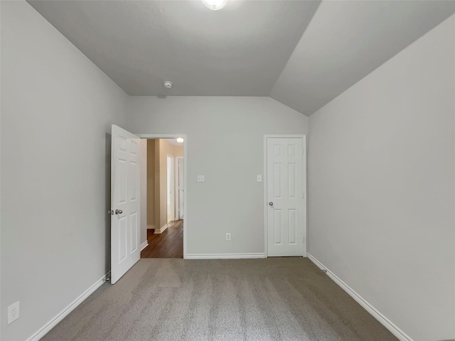 unfurnished bedroom with lofted ceiling and carpet floors