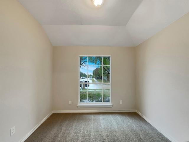 carpeted spare room featuring lofted ceiling