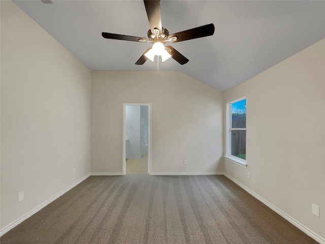 carpeted spare room featuring vaulted ceiling and ceiling fan