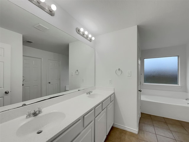 bathroom with tile patterned floors, vanity, and a tub