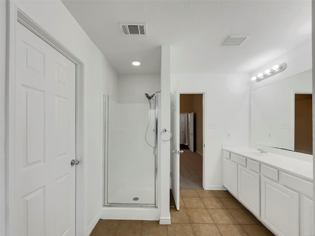 bathroom with tile patterned flooring, an enclosed shower, and vanity