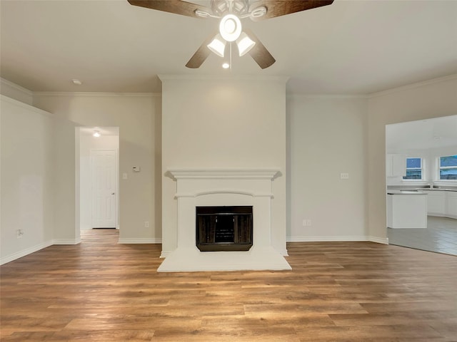 unfurnished living room with crown molding, ceiling fan, sink, and light wood-type flooring