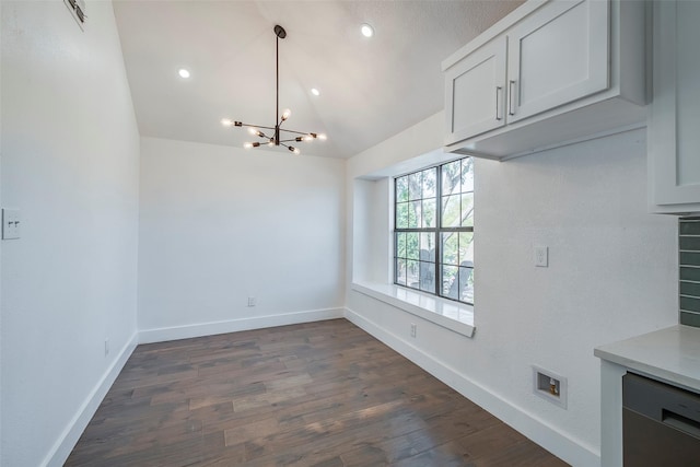 unfurnished dining area featuring an inviting chandelier, dark wood-type flooring, and lofted ceiling