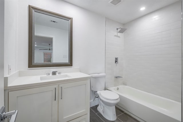 full bathroom featuring tiled shower / bath, vanity, tile patterned floors, and toilet