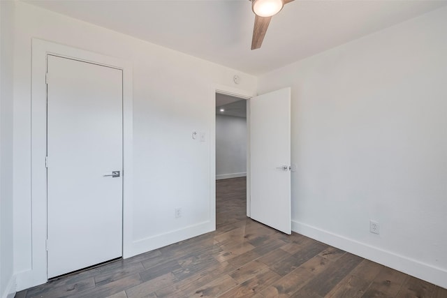 unfurnished bedroom featuring dark wood-type flooring and ceiling fan