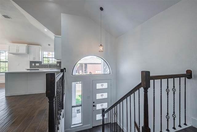 entrance foyer featuring dark wood-type flooring and high vaulted ceiling