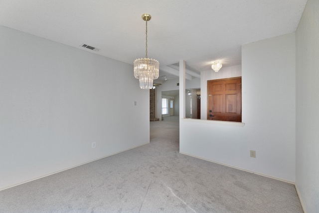 carpeted empty room with a notable chandelier