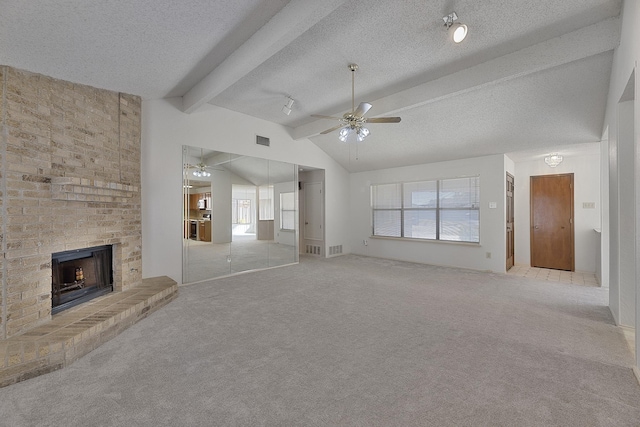 unfurnished living room with lofted ceiling with beams, a brick fireplace, light carpet, a textured ceiling, and ceiling fan