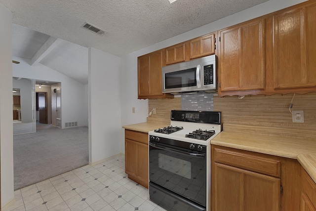 kitchen featuring lofted ceiling with beams, backsplash, light colored carpet, gas stove, and a textured ceiling